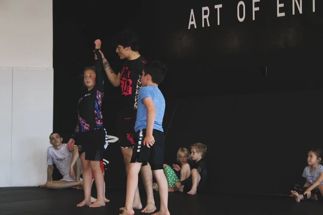 Kids working footwork and pad drills in a youth kickboxing class at AOE in Monterey